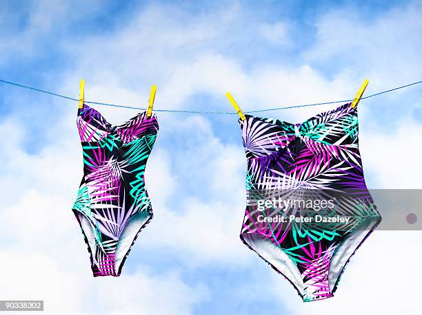 small and obese swimming costumes on washing - eendelig zwempak stockfoto's en -beelden