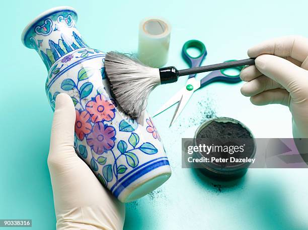 forensic scientist dusting vase for fingerprints. - beweismittel stock-fotos und bilder
