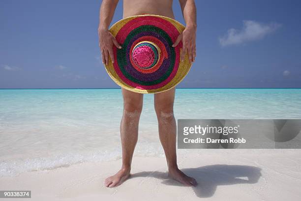 naked man holding a sombrero on tropical beach - nudity stock pictures, royalty-free photos & images