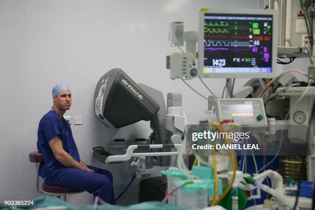 Britain's Prince William, Duke of Cambridge looks through a dual console of the da Vinci robot while lead surgeon Vin Paleri performs a minimally...