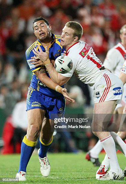 Feleti Mateo of the Eels offloads as he is tackled by Ben Creagh of the Dragons during the round 26 NRL match between the St George Illawarra Dragons...