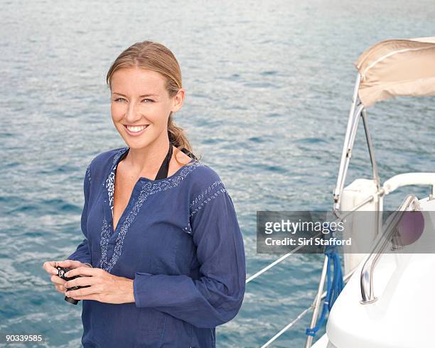 young woman on boat with camera in hand, smiling - siri stafford fotografías e imágenes de stock