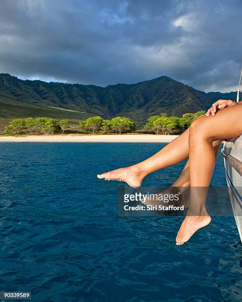 legs dangling off of edge of boat - siri stafford stock pictures, royalty-free photos & images