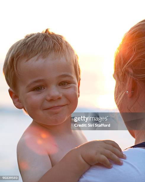 young boy in mother's arms, smiling - siri stafford fotografías e imágenes de stock