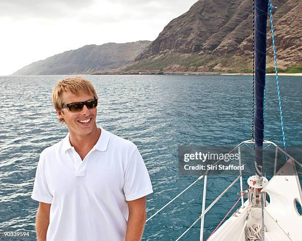 young man on sailboat, smiling - siri stafford stock pictures, royalty-free photos & images