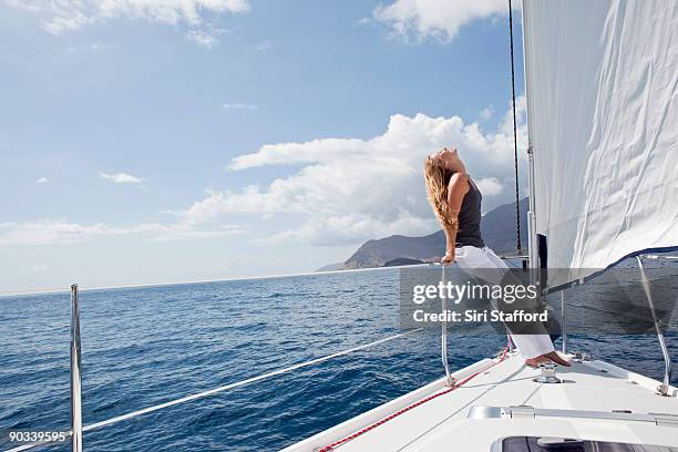 woman on bow of sailboat with hair blowing in wind - siri stafford stock pictures, royalty-free photos & images