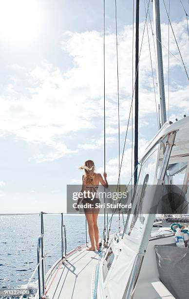 young woman walking towards bow of sailboat - siri stafford fotografías e imágenes de stock