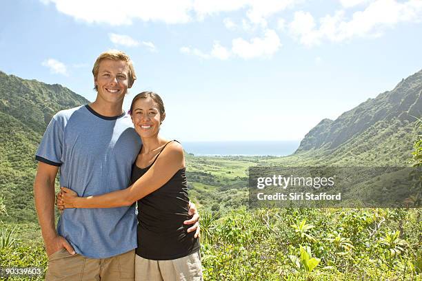 young couple in front of view of valley and ocean - siri stafford fotografías e imágenes de stock