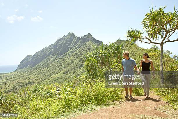 young couple hiking while looking at ocean view - affe bildbanksfoton och bilder