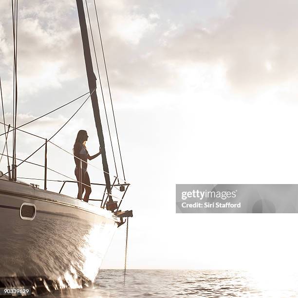 woman standing on bow of boat at sunset - siri stafford fotografías e imágenes de stock