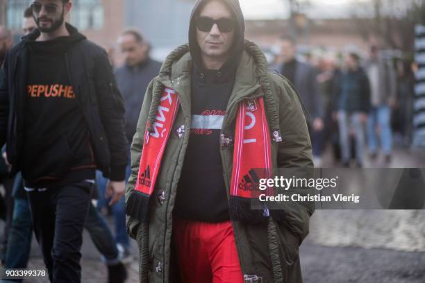 Alessandro Altomare wearing red Adidas scarf, olive parak, red track suit pants is seen during the 93. Pitti Immagine Uomo at Fortezza Da Basso on...