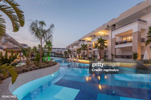 luxury construction hotel with swimming pool at sunset - hotel pool stock pictures, royalty-free photos & images