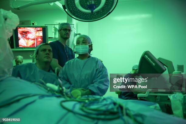 Prince William, Duke of Cambridge looks through a dual console of the da Vinci XI robot before a highly complex robotic cancer operation to remove a...