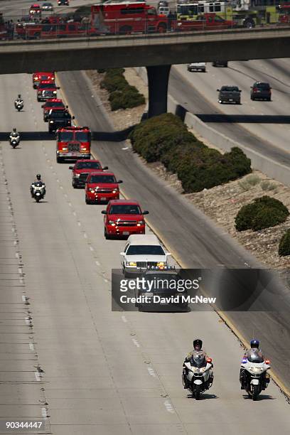 Firefighters escort the body of fallen firefighter Capt. Tedmund Hall, one of two firefighters who died in the 226-square-mile Station Fire, to a...