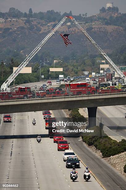 Firefighters escort the body of fallen firefighter Capt. Tedmund Hall, one of two firefighters who died in the 226-square-mile Station Fire, to a...