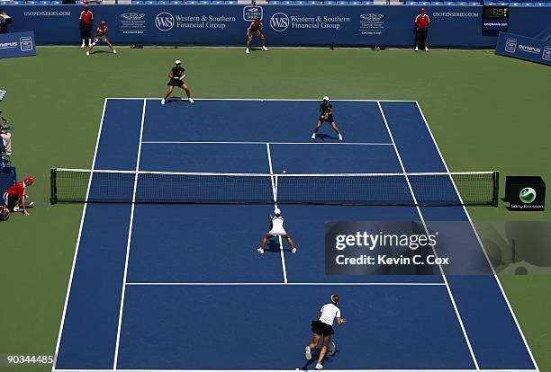 Maria Jose Martinez Sanchez of Spain serves as partner Nuria Llagostera Vives of Spain stands ready at the net during the double's final of the...