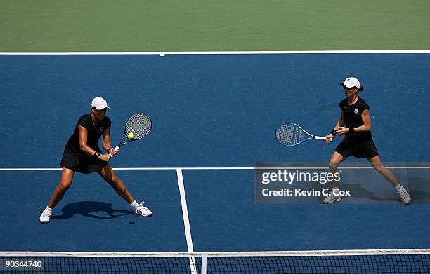 Cara Black of Zimbabwe looks on as partner Liezel Huber plays the backhand volley against Nuria Llagostera Vives and Maria Jose Martinez Sanchez,...