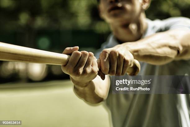 man practicing baseball bat swing - baseballschläger stock-fotos und bilder