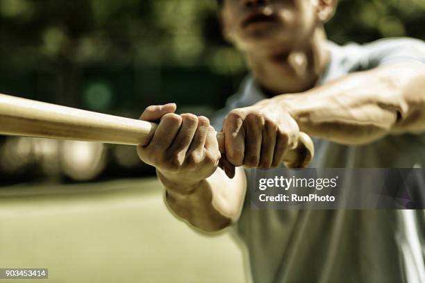 man practicing baseball bat swing - bastão de basebol imagens e fotografias de stock