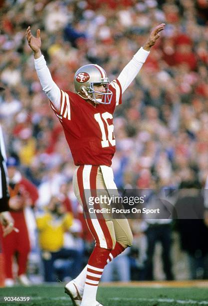 Joe Montana of the San Francisco 49ers throws his hand in the air after throwing a touchdown pass against the Miami Dolphins during Super Bowl XIX on...