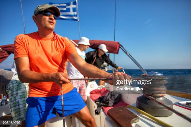 people on sailboat working as a team - cable winch stock pictures, royalty-free photos & images