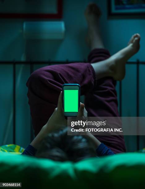 teenager with green screen in bed - computer-game-green-screen stock pictures, royalty-free photos & images