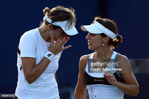 Nuria Llagostera Vives and Maria Jose Martinez Sanchez of Spain talk while playing against Camille Pin of France and Carla Suarez Navarro of Spain...