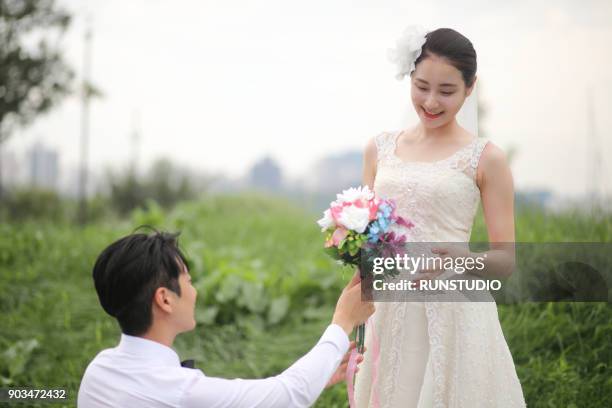 bridegroom giving bouquet to bride - korea tradition stock pictures, royalty-free photos & images