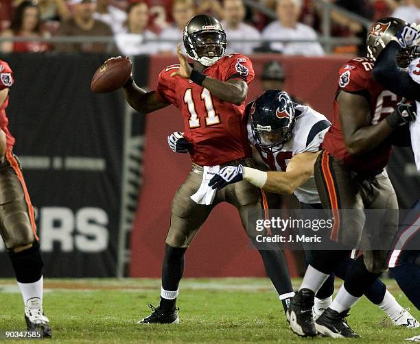 Quarterback Josh Johnson of the Tampa Bay Buccaneers is hit by defensive tackle Josh Leonard of the Houston Texans during a preseason game at Raymond...