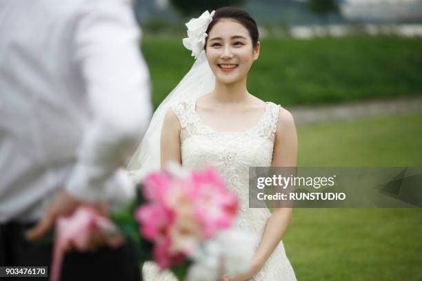 groom holding bouquet with bride in background - korea tradition stock pictures, royalty-free photos & images