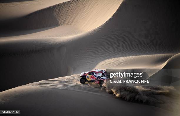 Toyota's Qatari driver Nasser Al-Attiyah and French co-driver Mathieu Baumel ride through the dunes of Tanaca during the 2018 Dakar Rally Stage 5...