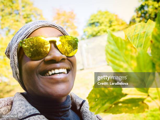 portrait of young african woman in park - sound effect stock pictures, royalty-free photos & images