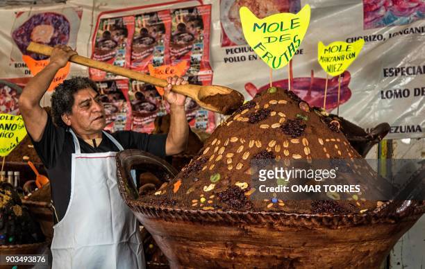Andres Ensaustegui Bernal arranges the display of mole powder with nuts and raisins, at his stall at the Mole Fair in San Pedro Atocpan, Milpa Alta...