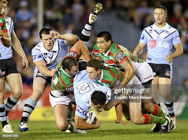 Anthony Tupou of the Sharks is up ended during the round 26 NRL match between the Cronulla Sharks and the South Sydney Rabbitohs at Toyota Stadium on...