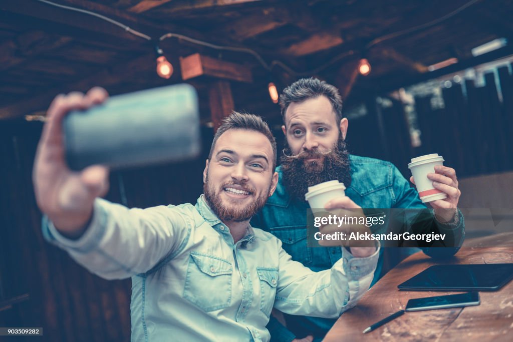 Two Bearded Friends Drinking Coffee and Taking Selfie in Restaurant