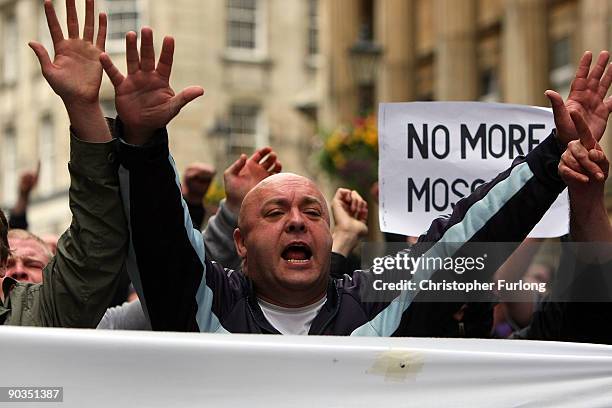 Members of the English Defence League hold make shift signs as they shout towards Police and anti-right wing protesters during a rally on September...