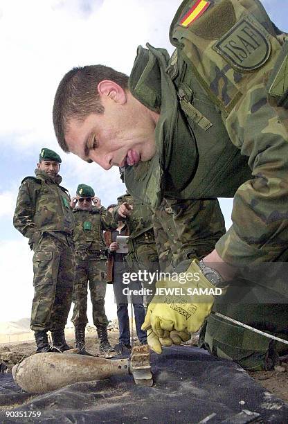 This file picture dated February 18, 2002 shows Sargent Gelo , a Spanish soldier from a special demining group, watched by colleagues as he checks an...