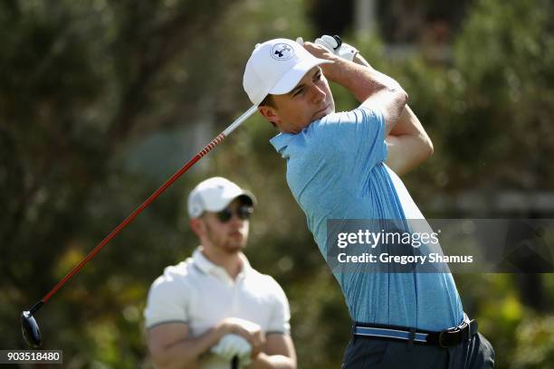 Jordan Spieth of the United States plays a shot as Nick Jonas looks on during the pro-am tournament prior to the Sony Open In Hawaii at Waialae...