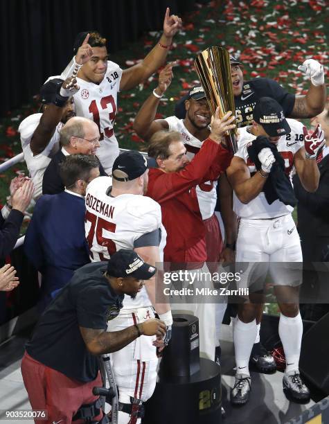 Head coach Nick Saban of the Alabama Crimson Tide holds up the National Championship Trophy surrounded by players after the College Football Playoff...