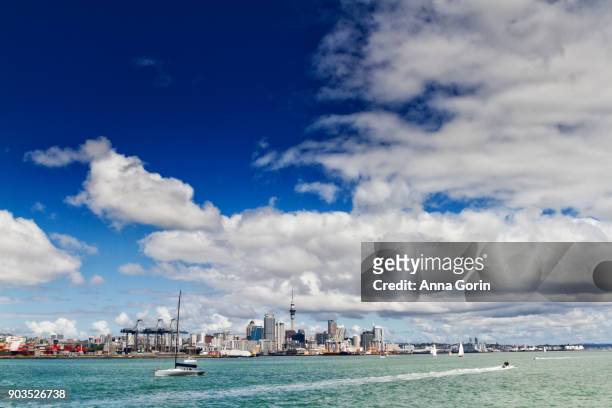 downtown auckland skyline seen across harbour from ferry to rangitoto island on partly cloudy summer afternoon, north island new zealand - auckland ferry stock pictures, royalty-free photos & images