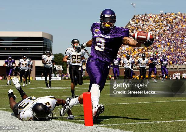 Mark LeGree of the Appalachian State Mountaineers dives as Brandon Jackson of the East Carolina Pirates scores a touchdown at Dowdy-Ficklen Stadium...