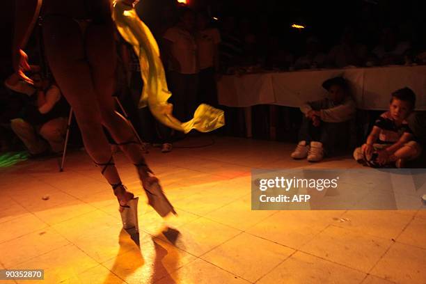 Two children watch a contestant during the Miss Gay Beauty pageant at a night club in Managua, September 4, 2009. AFP PHOTO/Mayerling GARCIA