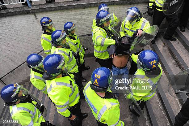 Protestor is moved by police officers during a demonstration organised by the English Defence League after they clashed with anti-fascists protestors...