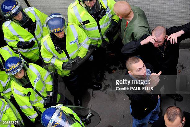 Protestors are moved by police officers during a demonstration organised by the English Defence League after they clashed with anti-fascists...