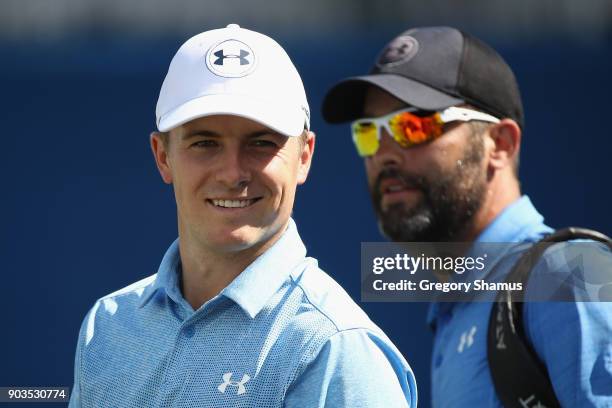 Jordan Spieth of the United States and caddie Michael Greller look on during the pro-am tournament prior to the Sony Open In Hawaii at Waialae...