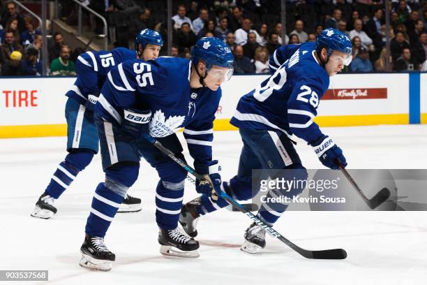 Andreas Borgman of the Toronto Maple Leafs, Matt Martin and Connor Brown waits for for a puck drop against the Columbus Blue Jackets during the first...