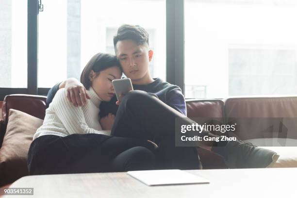 young couple relaxing on sofa - couple sleeping on sofa stock pictures, royalty-free photos & images