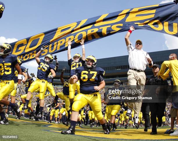 Head coach Rich Rodriguez enters the stadium with his team prior to playing the Western Michigan Broncos on September 5, 2009 at Michigan Stadium in...