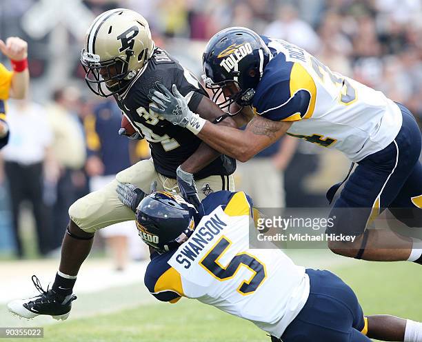 Antavian Edison of the Purdue Boilermakers is tackled by members of the Toledo Rockets at Ross-Ade Stadium on September 5, 2009 in West Lafayette,...