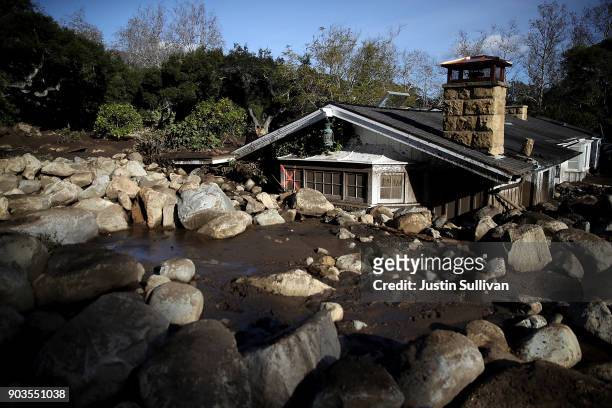 Debris from a mudslide covers a home on January 10, 2018 in Montecito, California. 15 people have died and hundreds are still stranded after massive...